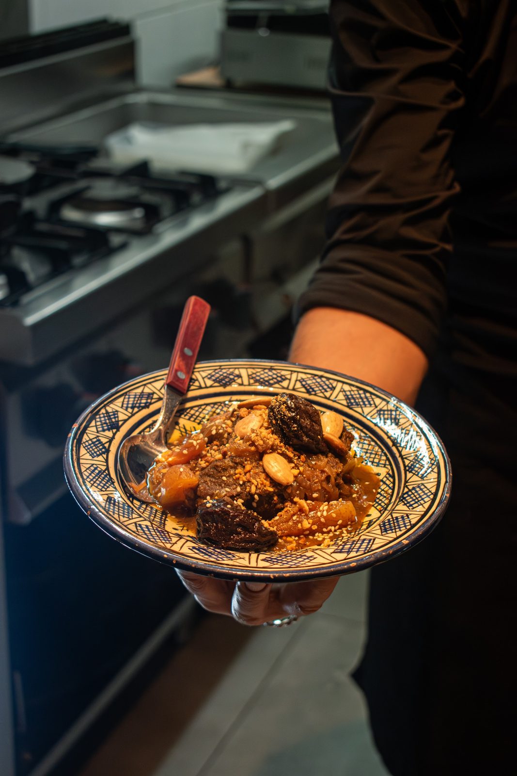 Chef serveert een dampende tajine vanuit de open keuken van restaurant La Sqala in Zwolle.