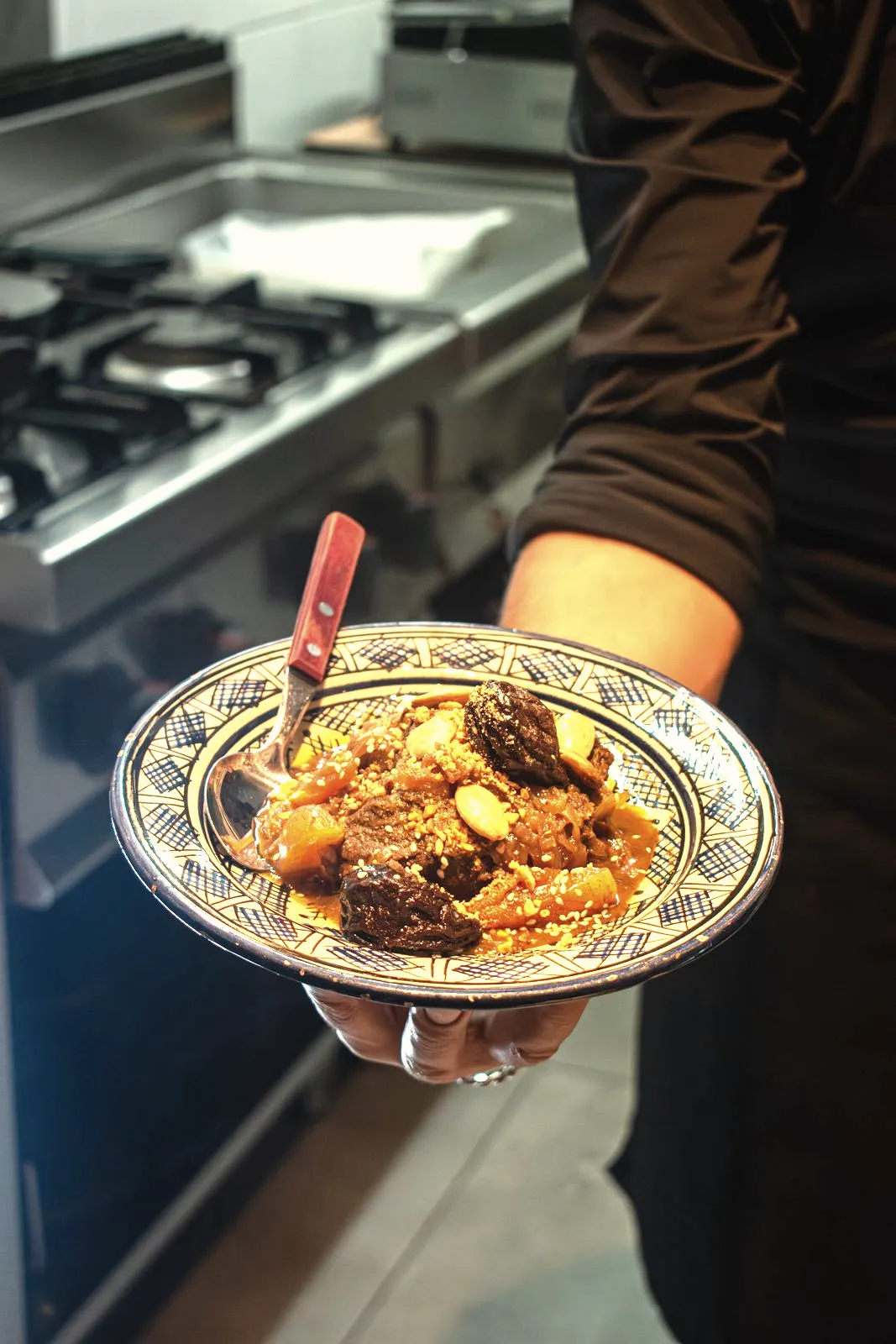 Chef serveert een dampende tajine vanuit de open keuken van restaurant LaSqala in Zwolle.